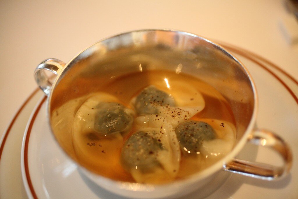 Kale ravioli with tomato broth.